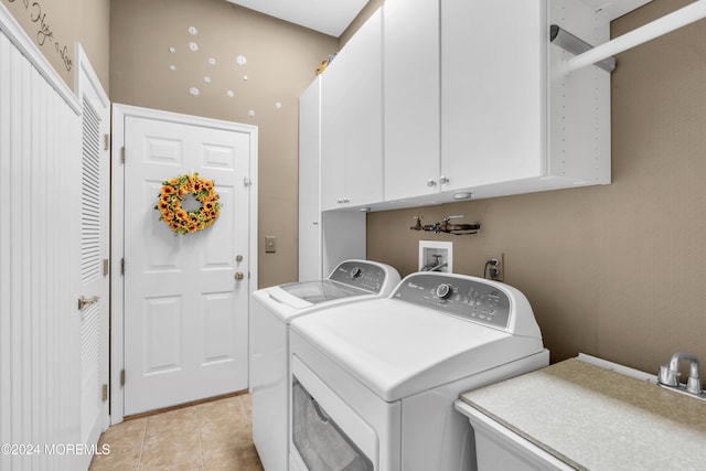 washroom with washer and clothes dryer, cabinets, sink, and light tile patterned floors