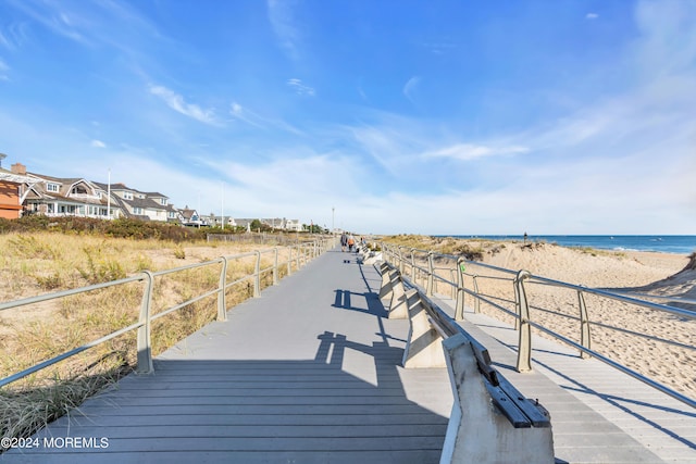 dock area featuring a water view and a beach view