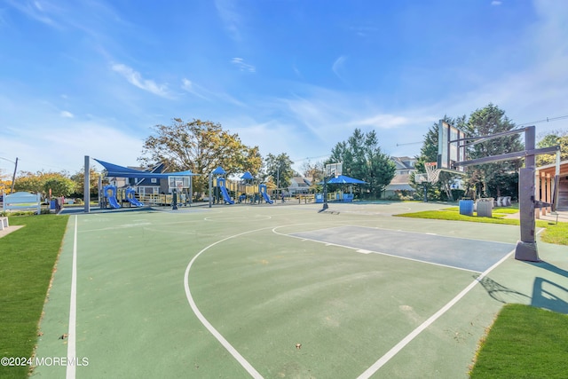 view of basketball court featuring a playground and a lawn