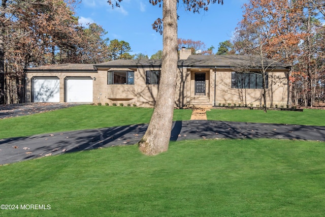 single story home with a front yard and a garage