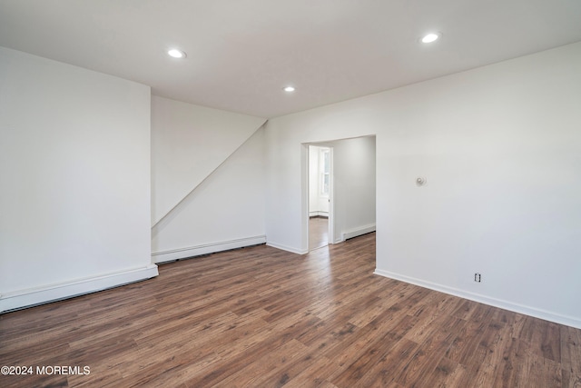 spare room featuring dark hardwood / wood-style flooring and a baseboard heating unit