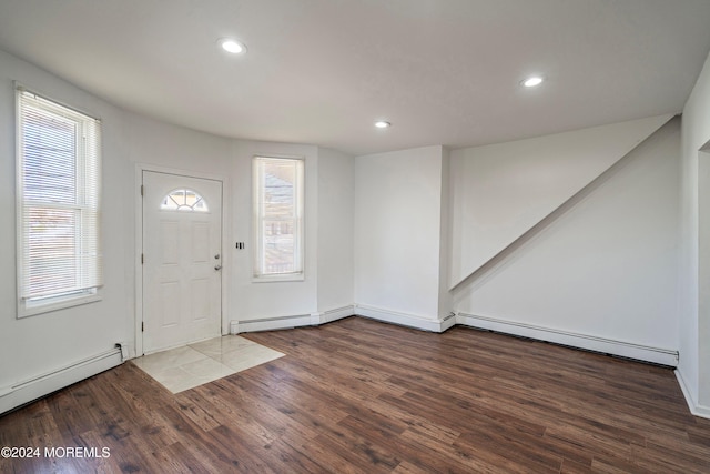 foyer with wood-type flooring, a healthy amount of sunlight, and baseboard heating