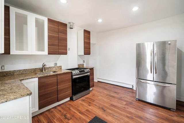 kitchen with sink, appliances with stainless steel finishes, light stone countertops, dark wood-type flooring, and a baseboard radiator