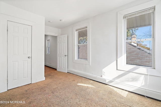 carpeted spare room featuring a baseboard radiator