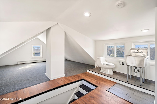 bonus room featuring baseboard heating, lofted ceiling, and hardwood / wood-style flooring