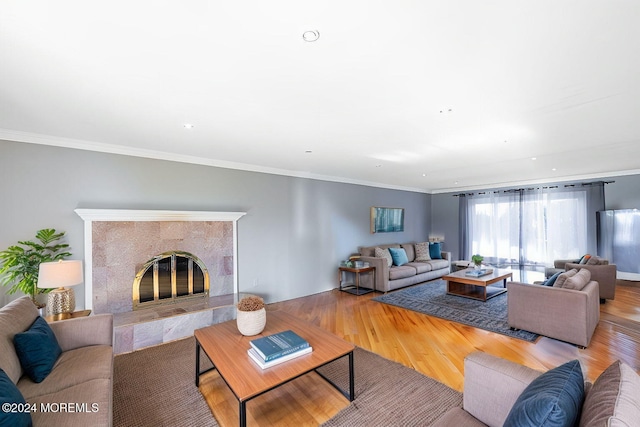 living room with crown molding, a fireplace, and hardwood / wood-style flooring