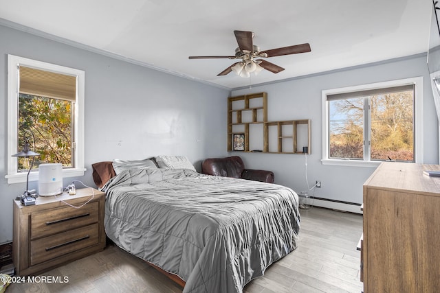 bedroom with baseboard heating, multiple windows, ceiling fan, and light hardwood / wood-style flooring