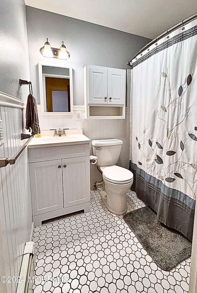 bathroom with baseboard heating, tile patterned flooring, vanity, and toilet