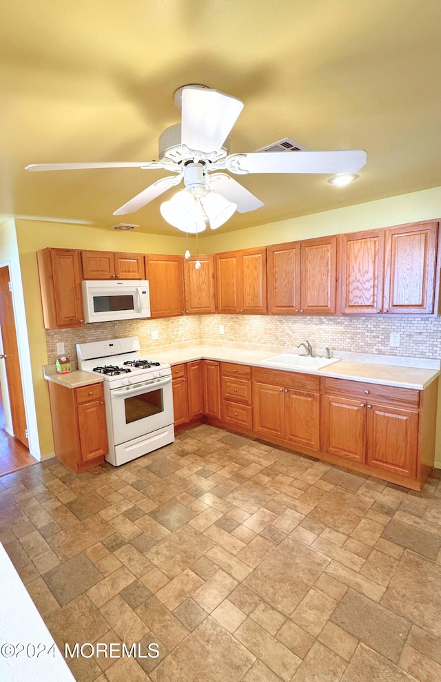 kitchen with backsplash, white appliances, sink, and ceiling fan