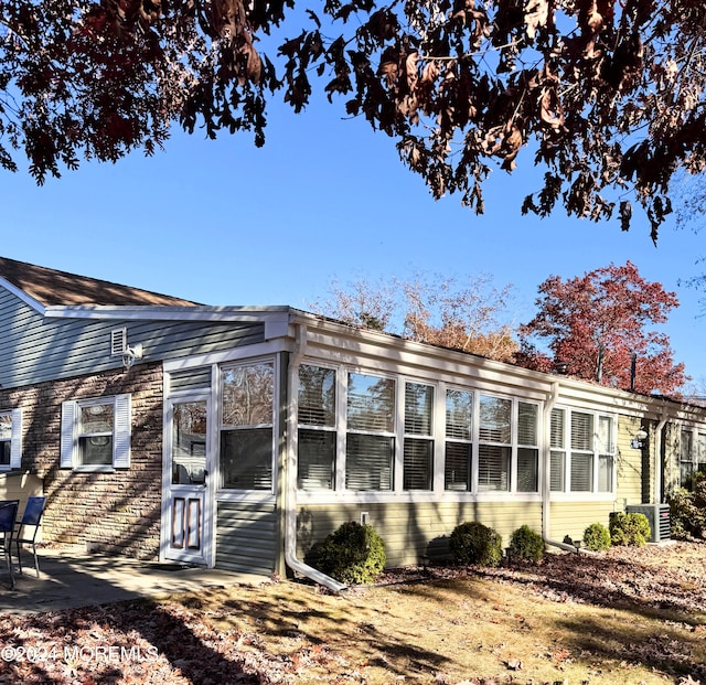 view of side of property with central air condition unit