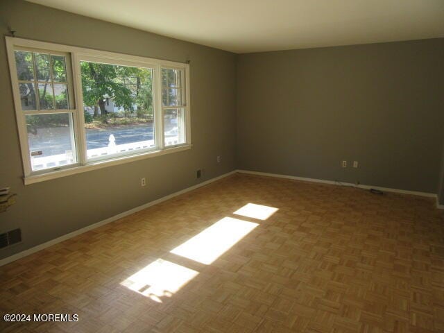 spare room with parquet flooring and plenty of natural light