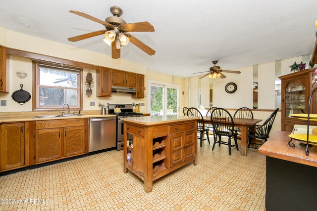 kitchen with a wealth of natural light, appliances with stainless steel finishes, sink, and a textured ceiling