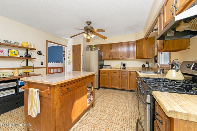 kitchen featuring appliances with stainless steel finishes, sink, and ceiling fan