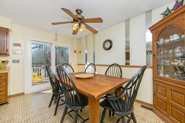 dining room with a textured ceiling and ceiling fan