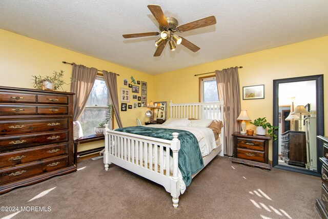 bedroom featuring a textured ceiling, ceiling fan, and dark carpet