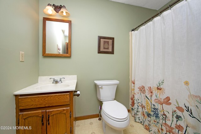 bathroom featuring a shower with shower curtain, vanity, and toilet