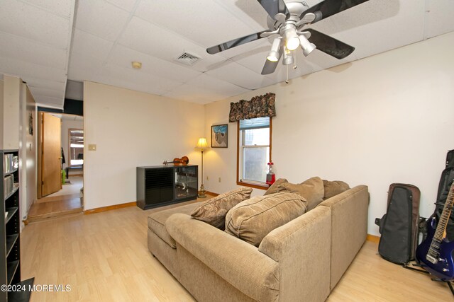 living room with a paneled ceiling, light wood-type flooring, and ceiling fan