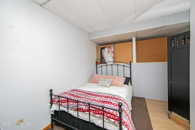 bedroom featuring a paneled ceiling and wood-type flooring