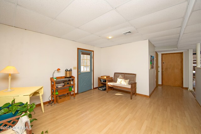 living area featuring light hardwood / wood-style floors and a paneled ceiling