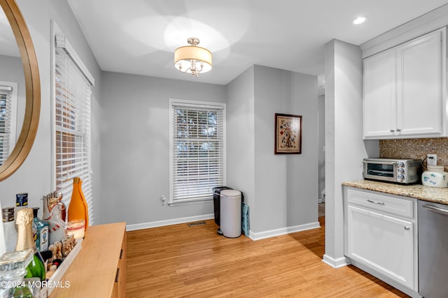 kitchen with white cabinetry, dishwasher, and light hardwood / wood-style floors