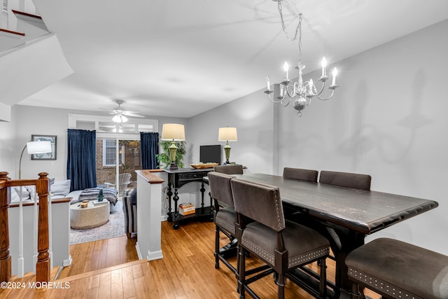 dining area with ceiling fan with notable chandelier and light hardwood / wood-style flooring