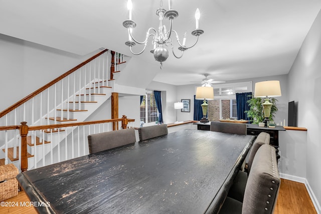 dining room with hardwood / wood-style floors and ceiling fan with notable chandelier