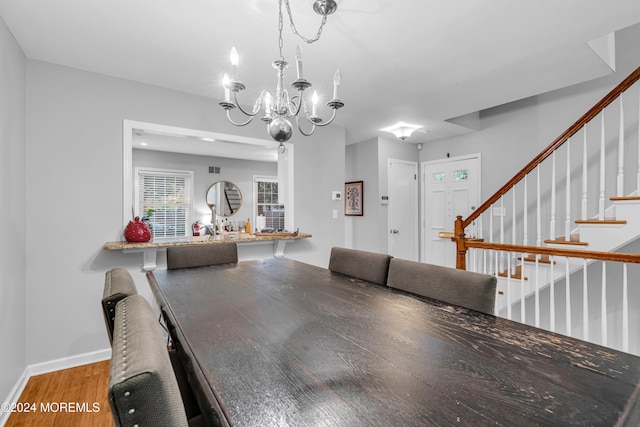 dining space featuring hardwood / wood-style floors and an inviting chandelier