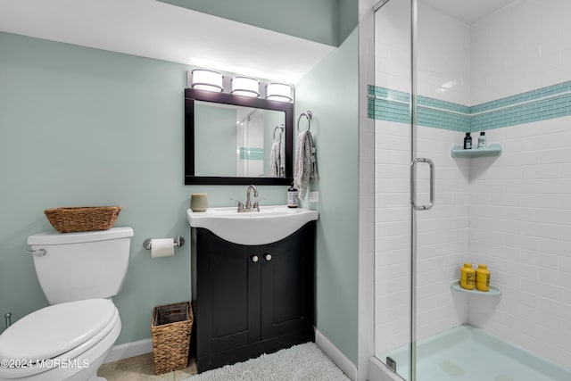 bathroom with vanity, toilet, and a shower with shower door