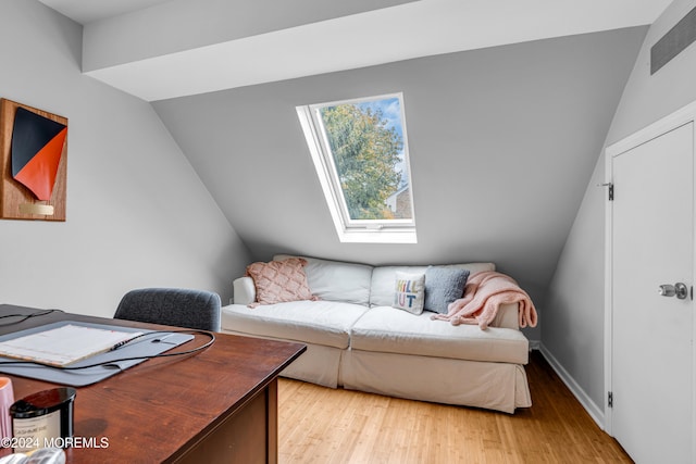 interior space with light hardwood / wood-style flooring and vaulted ceiling with skylight