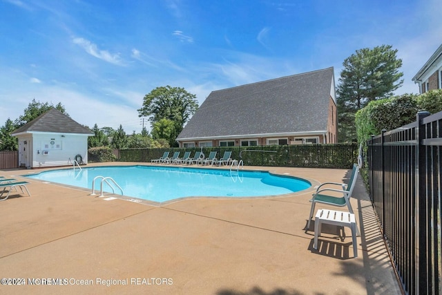 view of swimming pool with a patio area and an outdoor structure