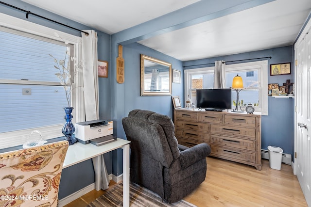 interior space featuring baseboard heating and light hardwood / wood-style floors