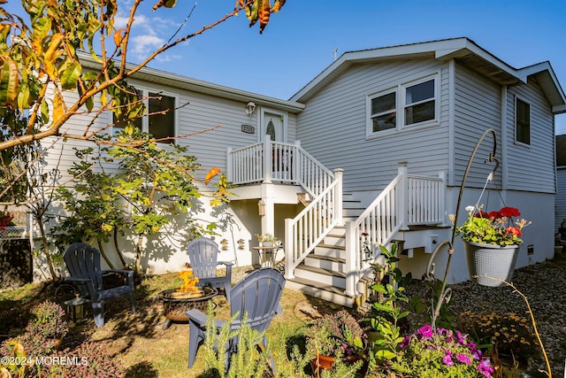 back of property with an outdoor fire pit