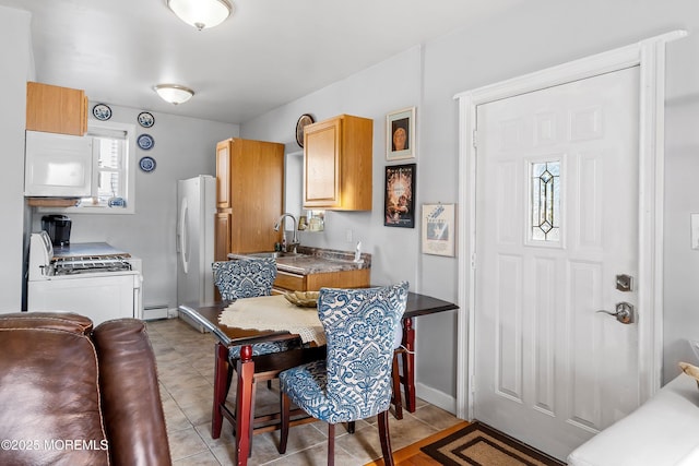 tiled dining room with sink and baseboard heating