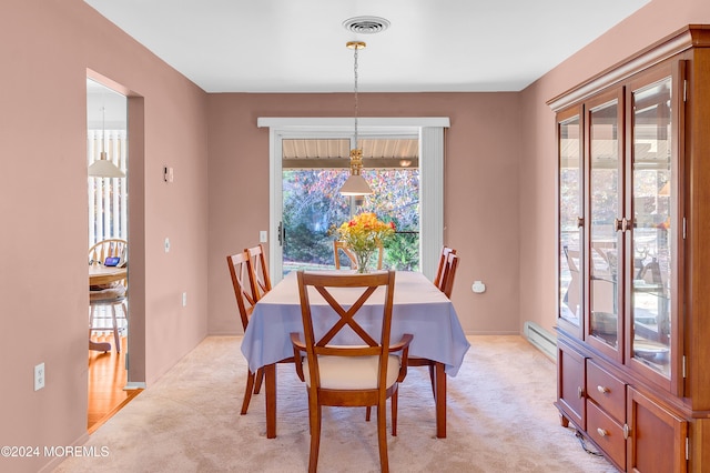 carpeted dining space with a baseboard heating unit