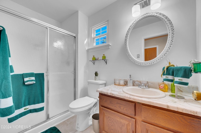 bathroom featuring tile patterned flooring, vanity, toilet, and a shower with shower door