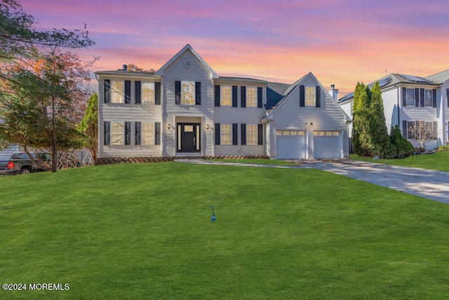 view of front of home with a garage and a lawn