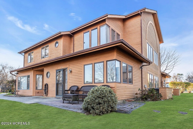 back of property featuring a lawn and a patio area