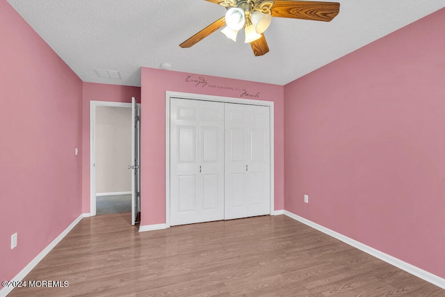 unfurnished bedroom with a closet, ceiling fan, a textured ceiling, and light hardwood / wood-style floors