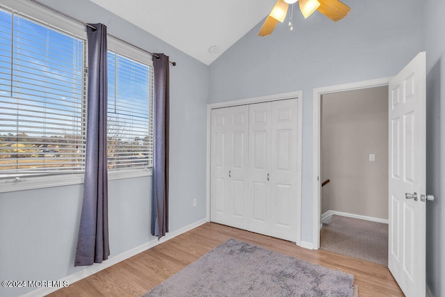 bedroom with light hardwood / wood-style floors, ceiling fan, a closet, and vaulted ceiling