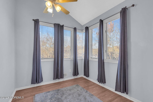 empty room with lofted ceiling, ceiling fan, and wood-type flooring