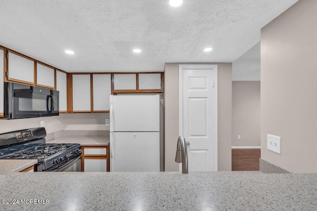 kitchen with black appliances, a textured ceiling, and sink