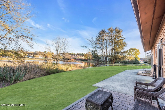 view of yard featuring a water view and a patio