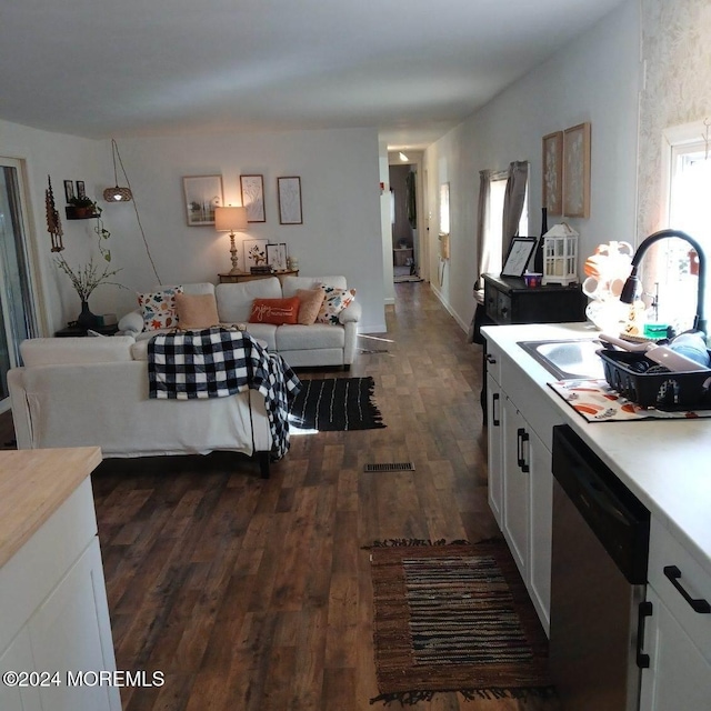 kitchen featuring dishwasher, white cabinets, dark wood-type flooring, and sink