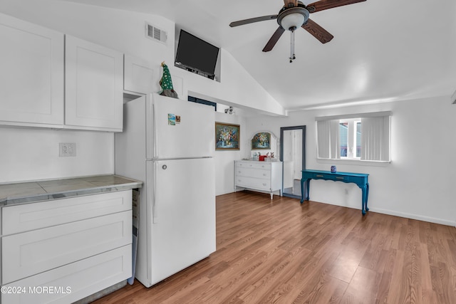 kitchen with light hardwood / wood-style floors, tile countertops, white cabinetry, lofted ceiling, and white refrigerator