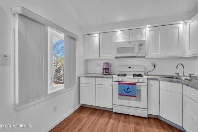 kitchen with white appliances, white cabinetry, and sink