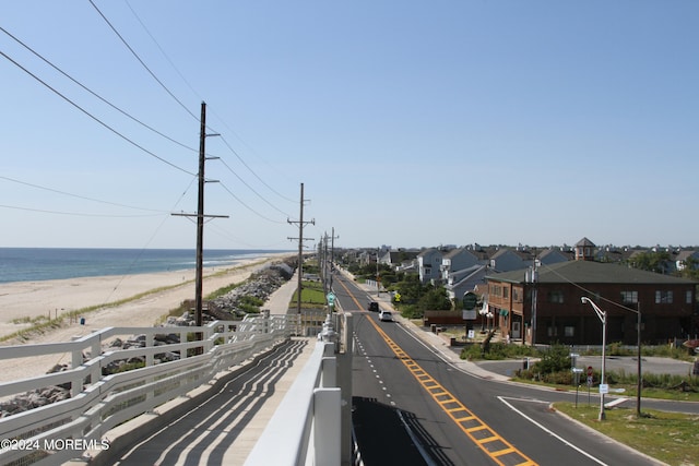 view of road with a view of the beach and a water view