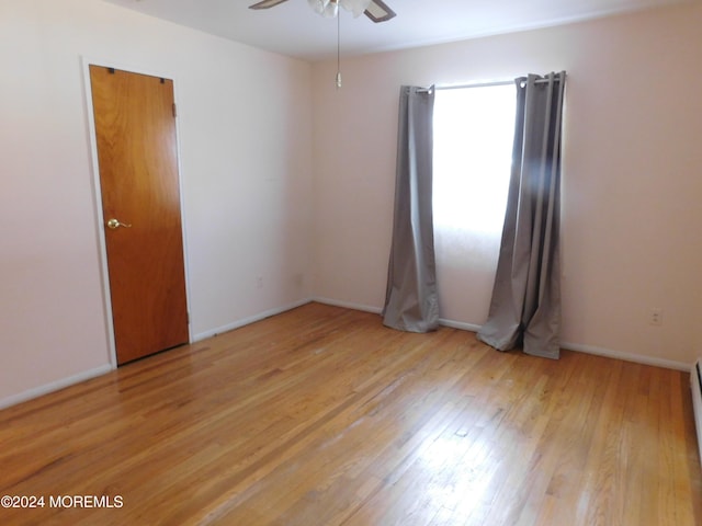 empty room with light wood-type flooring and ceiling fan