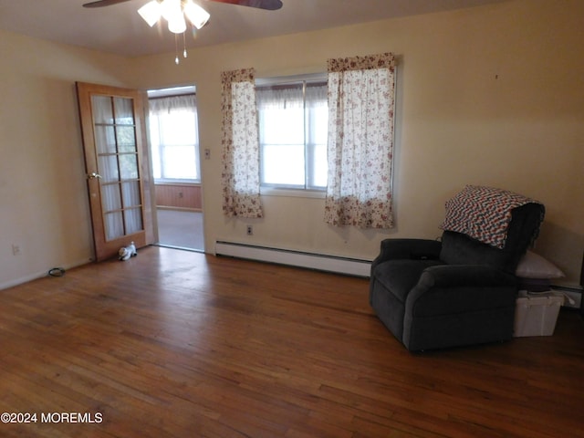 sitting room with dark hardwood / wood-style flooring, ceiling fan, and a baseboard radiator