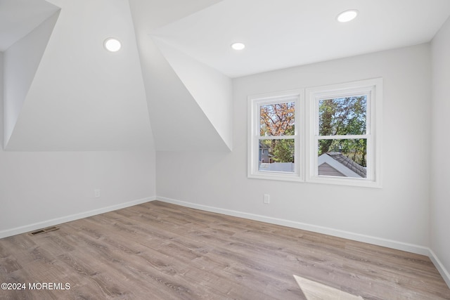 bonus room with vaulted ceiling and light hardwood / wood-style flooring