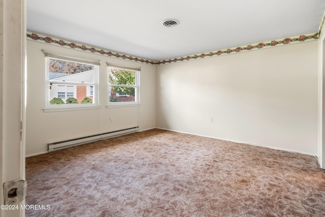 carpeted empty room featuring baseboard heating